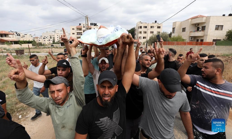 Mourners and relatives carry the body of a Palestinian man, who was killed by Israeli soldiers, during his funeral in the West Bank city of Jenin, Oct. 8, 2022.(Photo: Xinhua)