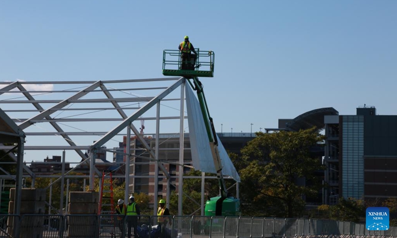 Laborers work at the construction site of a humanitarian emergency response and relief center for asylum seekers on Randall's Island in New York, the United States, on Oct. 9, 2022. The thousands of newly arrived asylum seekers in New York City, the most populous city in the United States, are facing multifaceted challenges in taking roots amid an ongoing humanitarian crisis.(Photo: Xinhua)