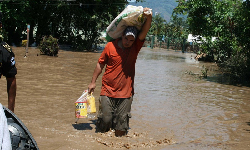 A resident walks in the flood in Izabal Province, Guatemala, May 31, 2010.(Photo: Xinhua)