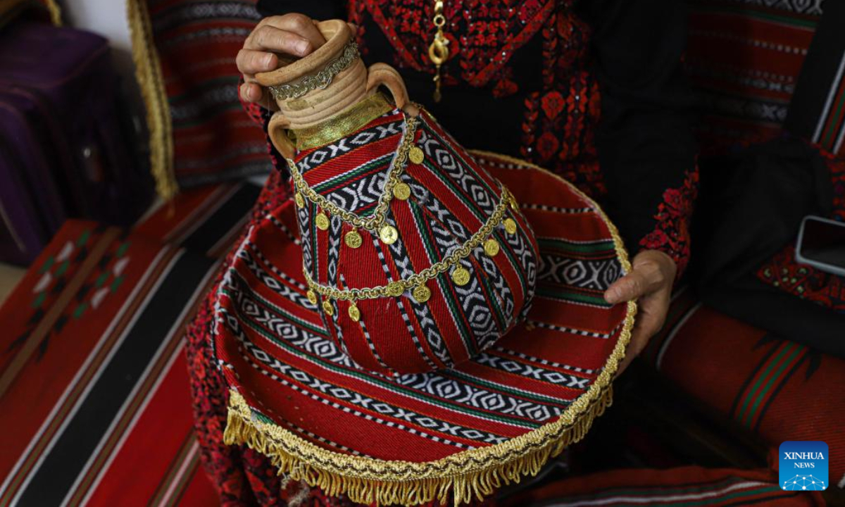 A woman presents an artifact at a festival to celebrate the Palestinian National Heritage Day, in Gaza City, Oct 11, 2022. A festival featuring Palestinian folklore was held in Gaza on Tuesday and Wednesday to celebrate the Palestinian National Heritage Day. Photo:Xinhua