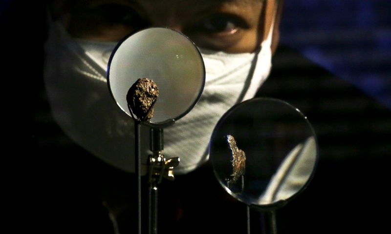 A woman takes a close look at the Pantar and Bondoc meteorites as they are unveiled at the Philippine National Museum in Manila, the Philippines, Oct. 11, 2022.(Photo: Xinhua)