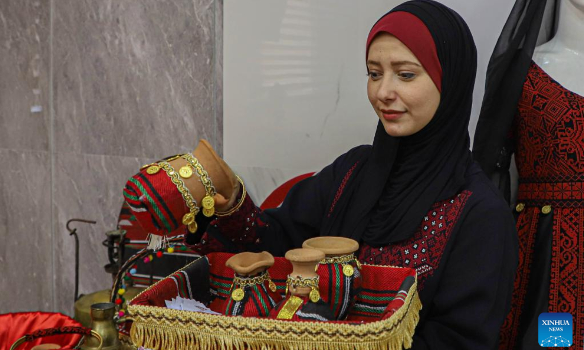 A woman arranges artifacts at a festival to celebrate the Palestinian National Heritage Day, in Gaza City, Oct 11, 2022. A festival featuring Palestinian folklore was held in Gaza on Tuesday and Wednesday to celebrate the Palestinian National Heritage Day. Photo:Xinhua