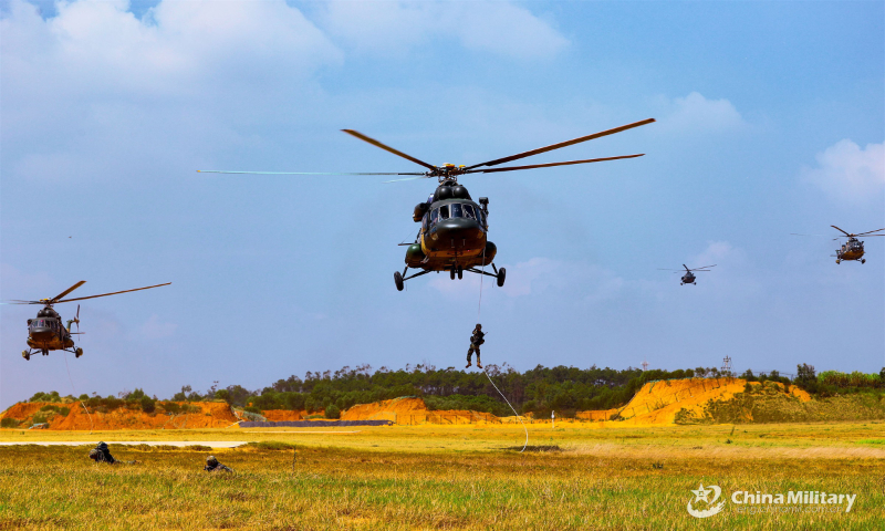 A soldier assigned to an army aviation brigade under the PLA 72nd Group Army rappels from a transport helicopter during the fast-roping training in September 10, 2022. (eng.chinamil.com.cn/Photo by Zhang Huanpeng)