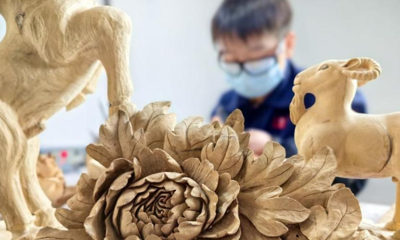 A craftsman makes wood carving at a studio in Heze, east China's Shangdong Province. Photo: China News Service