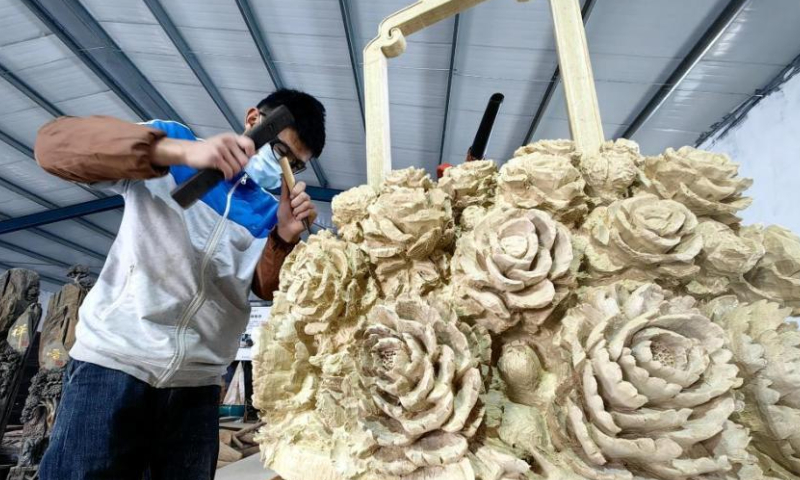 A craftsman makes wood carving at a studio in Heze, east China's Shangdong Province. Photo: China News Service