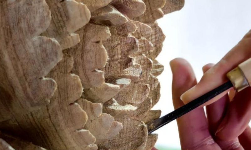 A craftsman makes wood carving at a studio in Heze, east China's Shangdong Province. Photo: China News Service