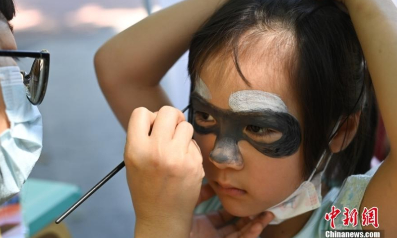 A kid tries face painting at the Guangzhou Zoo in south China's Guangdong Province, 2022. Photo: China News Service