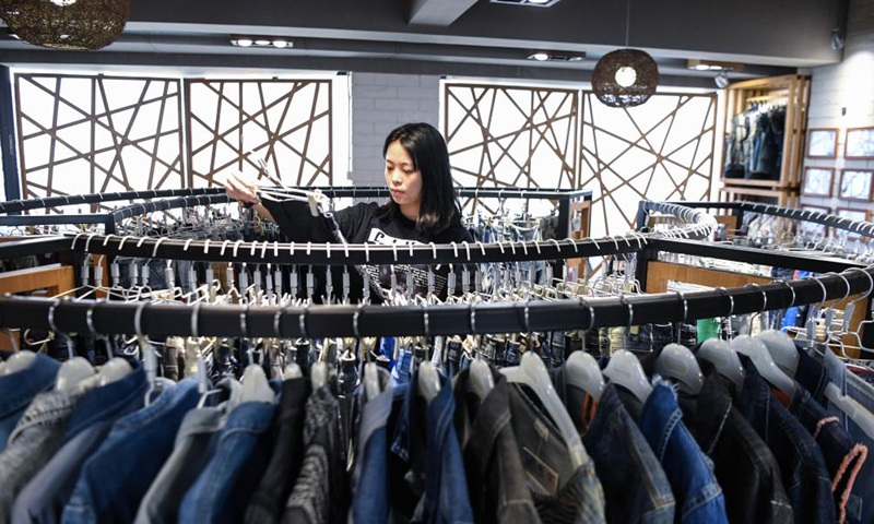 A staff member sorts clothes to be displayed online for the 132nd session of the China Import and Export Fair, also known as the Canton Fair, at Guangdong Textiles Import & Export Co., Ltd. in Guangzhou, south China's Guangdong Province, Oct. 14, 2022.Photo:Xinhua