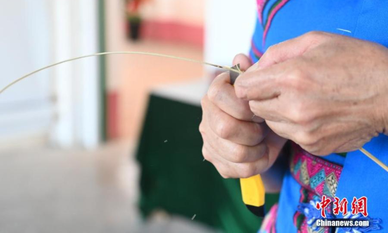 Tan cuts a bamboo strip in Huangjiang Maonan autonomous county, south China's Guangxi Zhuang autonomous region, Oct. 15, 2022. (Photo: China News Service/Wang Yizhao)