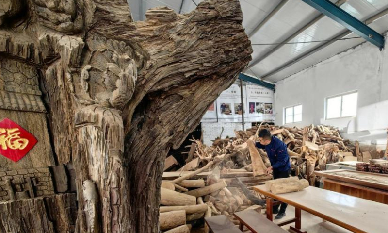 A craftsman makes wood carving at a studio in Heze, east China's Shangdong Province. Photo: China News Service