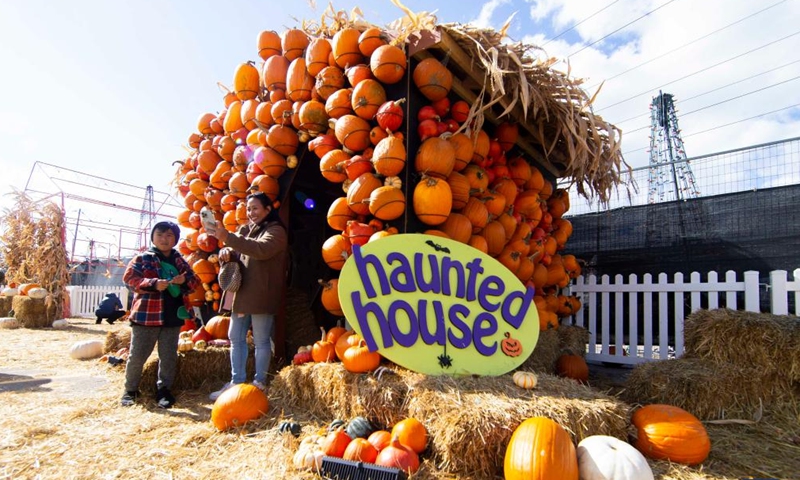 A visitor takes a selfie in front of a haunted house made of pumpkins at the Pumpkinville in Toronto, Canada, Oct. 15, 2022.Photo:Xinhua