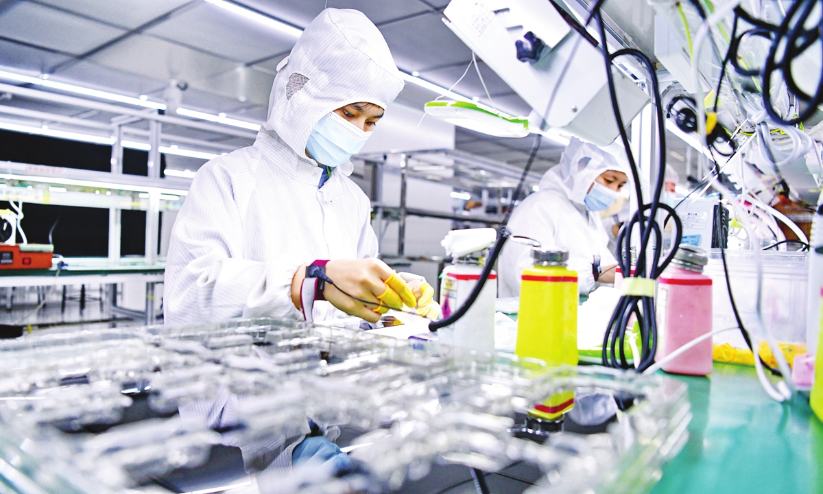 Employees process 5G phone screens for export at an electronic product production firm in Ganzhou, East China's Jiangxi Province. Photo: VCG