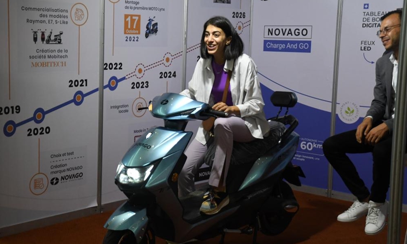 A woman tries an electric motorcycle at the first International Fair of Energy Transition in Tunis, Tunisia, on Oct. 19, 2022.Photo:Xinhua