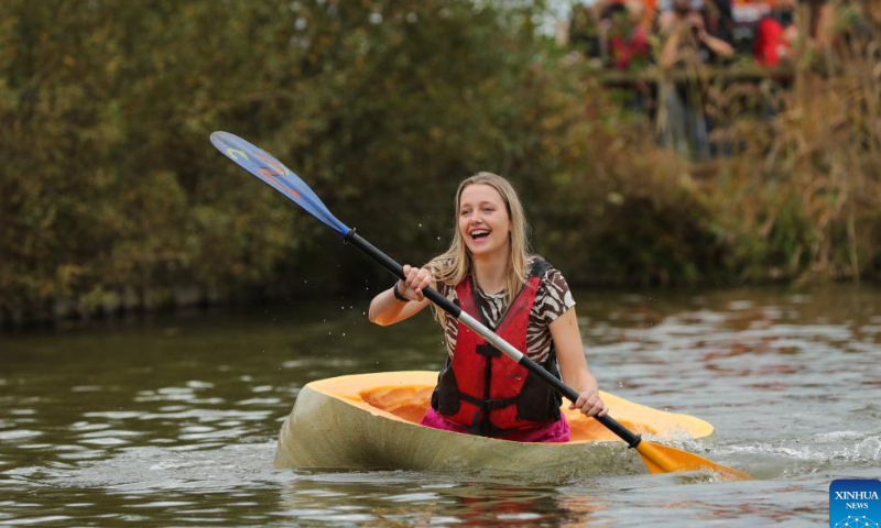 A woman competes in the pumpkin regatta in the village of Lichtaart of Kasterlee, Belgium, Oct. 23, 2022. The 13th edition of pumpkin regatta is a kayaking competition in Belgium, attracting participants to sit and compete in large hollow-out pumpkins. According to local organizers, the weight of each pumpkin that was made into a boat could reach hundreds of kilograms. Photo: Xinhua