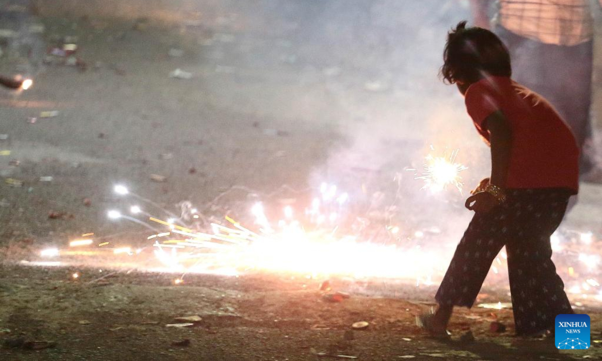 A kid lights firecrackers to celebrate Diwali, or the festival of lights, in Bangalore, India, Oct 24, 2022. Photo:Xinhua