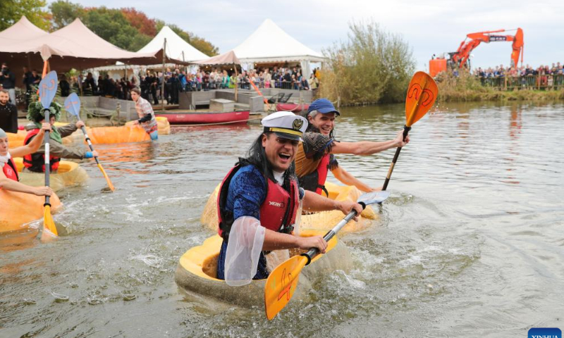 People compete in the pumpkin regatta in the village of Lichtaart of Kasterlee, Belgium, Oct. 23, 2022. The 13th edition of pumpkin regatta is a kayaking competition in Belgium, attracting participants to sit and compete in large hollow-out pumpkins. According to local organizers, the weight of each pumpkin that was made into a boat could reach hundreds of kilograms. Photo: Xinhua