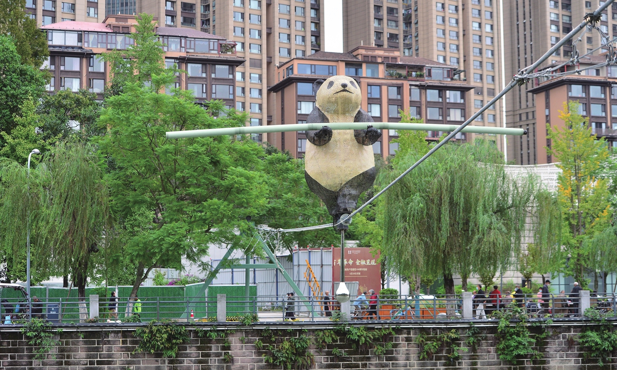 A bamboo-woven panda carefully holding a balanced prop crossed the two banks by walking a steel wire in the air above the riverway next to the Living Water Garden, Chengdu, Southwest China's Sichuan Province on October 26, 2022. Chengdu has the largest research base of giant panda breeding. Photo: IC