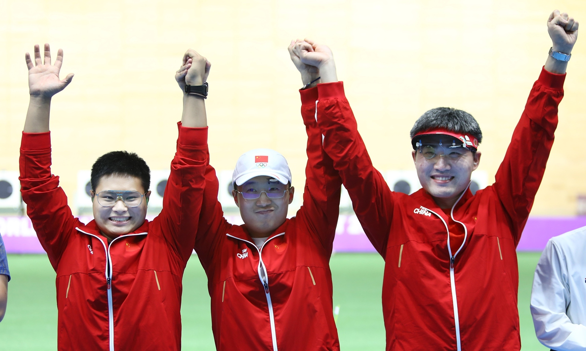 (From left) Zhang Jueming, Li Yuehong and Lu Zhiming of China celebrate after winning the 25-meter rapid fire pistol men's team gold medal between China and Ukraine in Cairo, Egypt on October 24, 2022. Photo: AFP