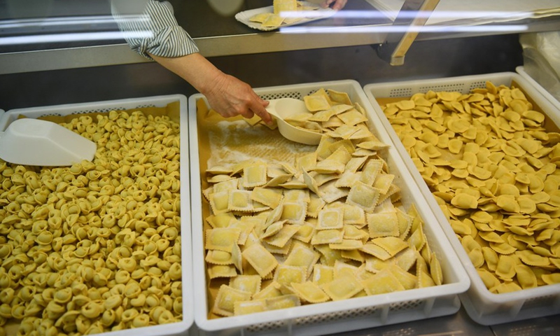 A saleswoman puts ravioli into a plate in Rome, Italy, on May 19, 2022.(Photo: Xinhua)