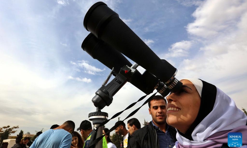 A woman observes a partial solar eclipse through a telescope in Amman, Jordan, Oct. 25, 2022.(Photo: Xinhua)