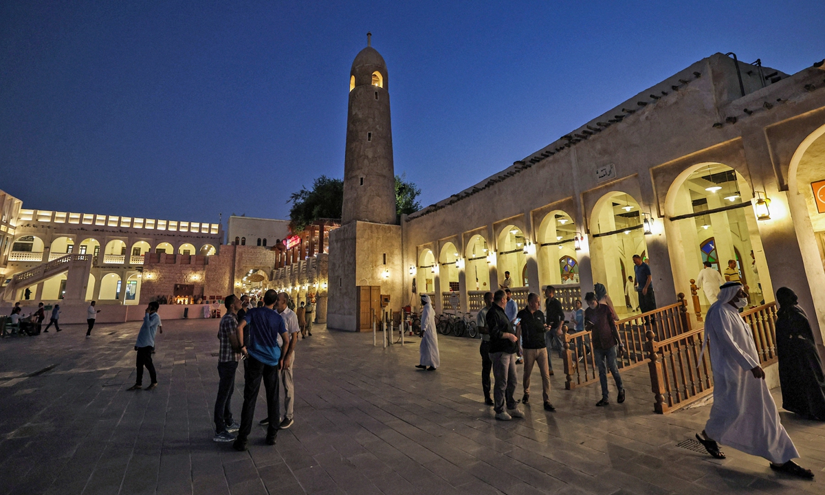 People walk past a mosque in Souq Waqif in the Qatari capital Doha on October 13, 2022, ahead of the Qatar 2022 FIFA World Cup. Photo: AFP