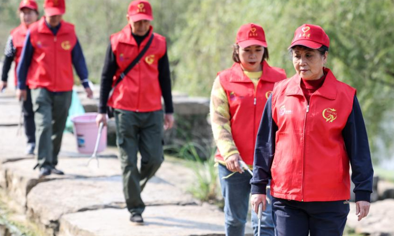 Zhou Yuqing (front) and other environmental protection volunteers patrol the Huaxi national city wetland park in Guiyang, capital of southwest China's Guizhou Province on Nov. 4, 2022. Photo: Xinhua