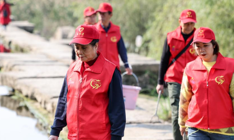 Zhou Yuqing (front) and other environmental protection volunteers patrol the Huaxi national city wetland park in Guiyang, capital of southwest China's Guizhou Province on Nov. 4, 2022. Photo: Xinhua