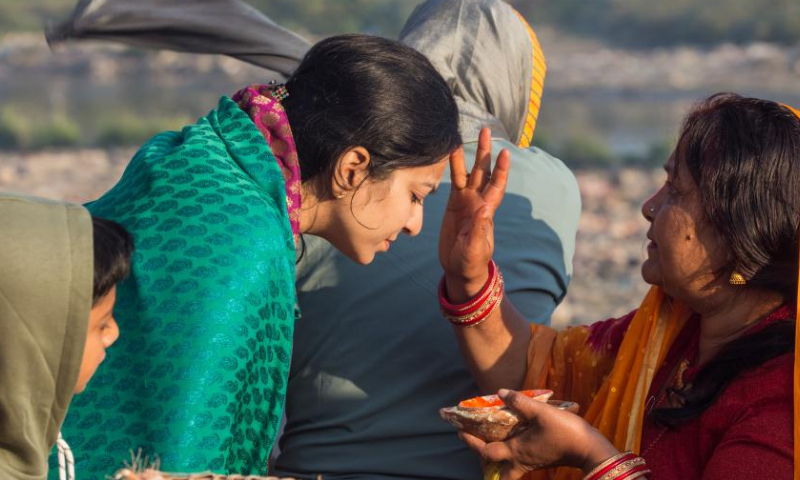 A devotee receives tika on her forehead after worshipping the rising sun during the Chhath festival on the bank of the Bagmati River in Kathmandu, Nepal, Oct. 31, 2022. The Chhath festival is dedicated to the sun, which is regarded as a token of stability and prosperity, and a Vedic goddess Chhathi Maiya. (Photo by Hari Maharjan/Xinhua)