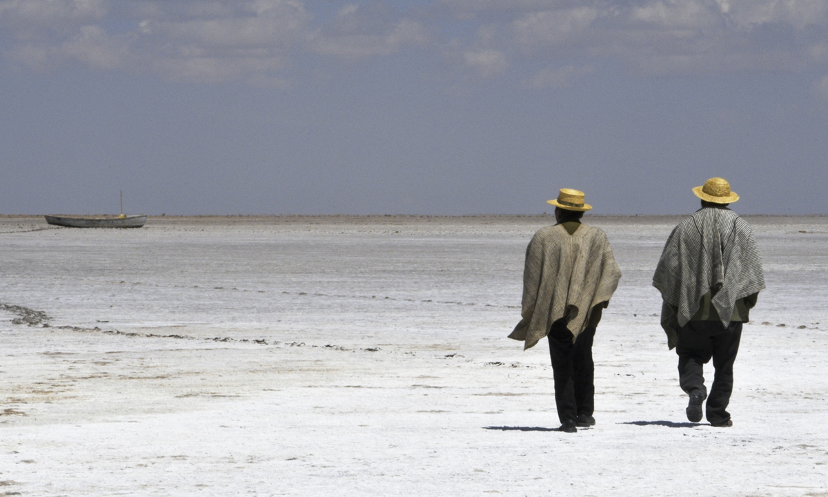 Felix Mauricio (left) and Pablo Flores, members of the Uru indigenous community, walk on the dried bed of former Lake Poopo, near the village of Punaca Tinta Maria, Bolivia. Photo: AFP