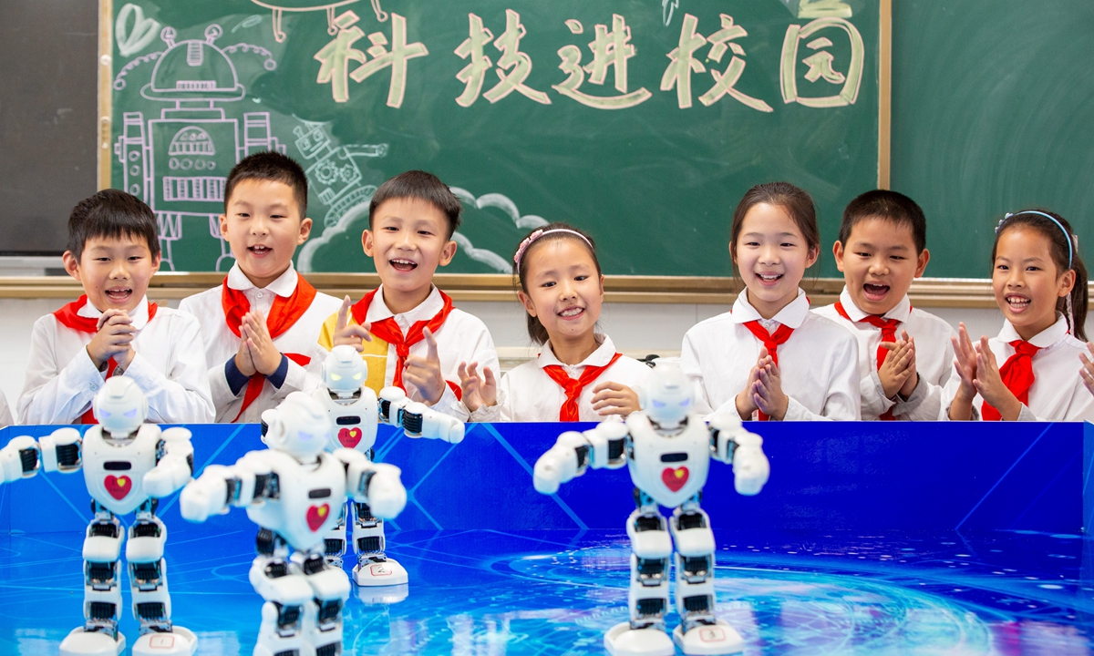 Primary school students interact with intelligent robots in Hai'an, East China's Jiangsu Province on November 3, 2022. The Chengnan Experimental Primary School has launched robot lessons to let students experience the attractions of artificial intelligence. Photo: VCG