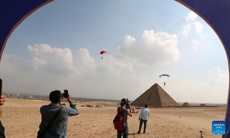 People watch the skydiving performance by jumpers over pyramids during the skydiving festival Jump Like a Pharaoh in Giza, Egypt, on Nov. 2, 2022.(Photo: Xinhua)