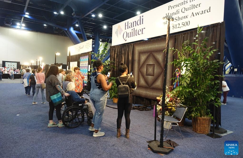 Visitors look at quilts during Houston International Quilt Festival