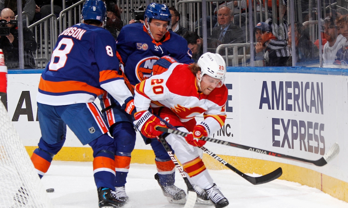 Noah Dobson #8 and Zach Parise #11 of the New York Islanders check Blake Coleman #20 of the Calgary Flames during the first period at the UBS Arena on November 7, 2022 in Elmont, New York. Photo: AFP