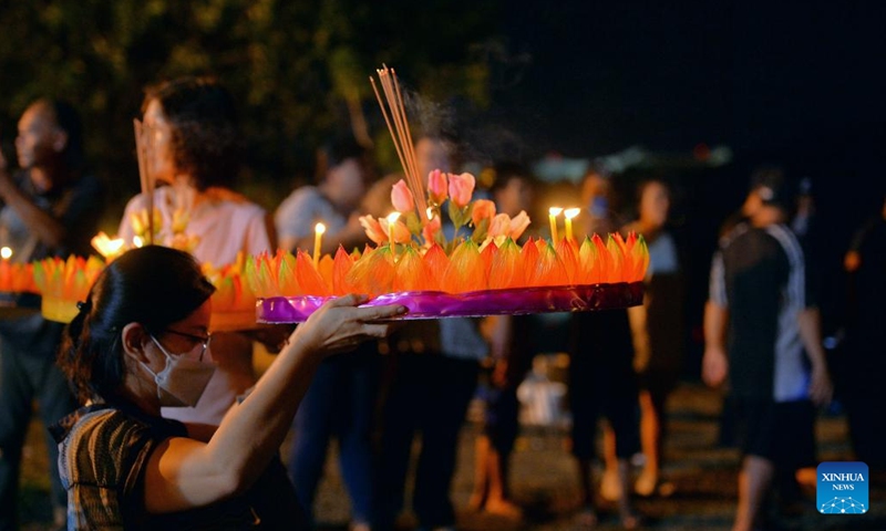 A woman prepares to release a water lantern in Bandar Seri Begawan, Brunei, on Nov. 8, 2022. The Thailand's traditional Loy Krathong Festival falls on Tuesday this year. Over 100 people including some Thai people living in Brunei released water lanterns for peace and luck.(Photo: Xinhua)