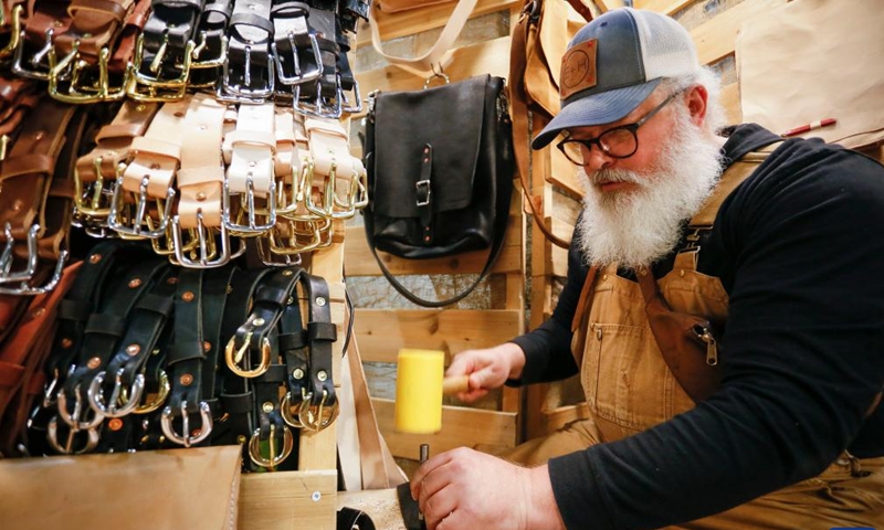 A vendor demonstrates the making of a leather belt at the Circle Craft Christmas Market in Vancouver, British Columbia, Canada, on Nov. 9, 2022.(Photo: Xinhua)