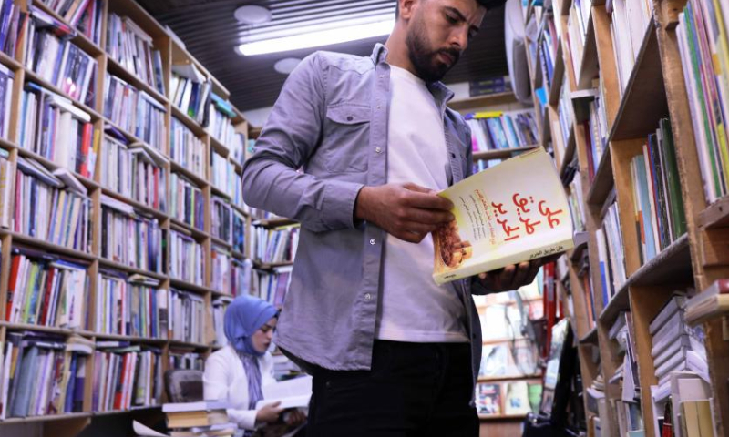 An Iraqi student reads a book on the Belt and Road Initiative, at a bookstore in Baghdad, Iraq, Nov. 21, 2022. (Xinhua/Khalil Dawood)