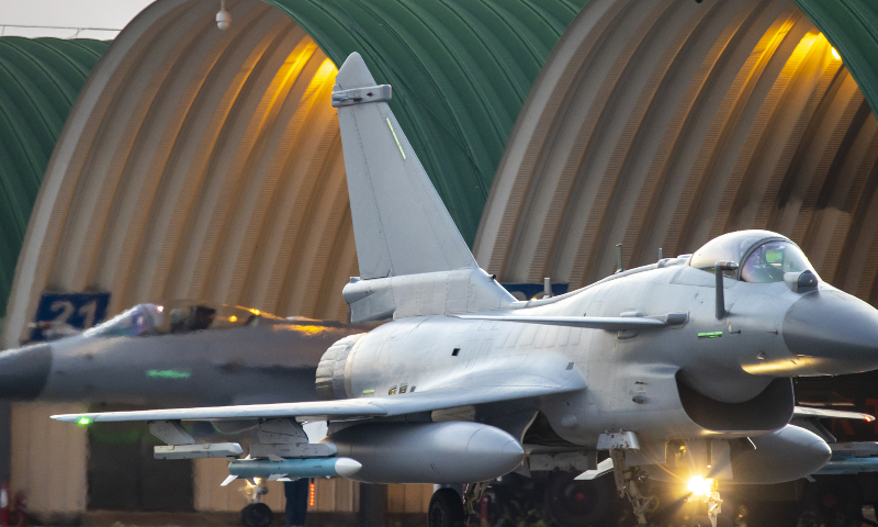 Fighter jets attached to an aviation brigade of the air force under the PLA Southern Theater Command taxi out of the hangers successively in sunset prior to a round-the-clock flight training mission on November 8, 2022. (eng.chinamil.com.cn/Photo by Wang Guoyun)