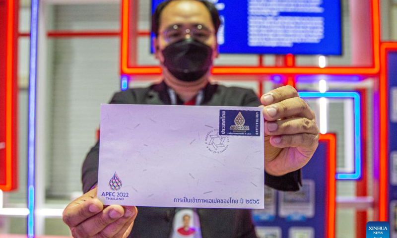 A staff member displays the commemorative envelope and stamp for the APEC 2022 at the media center of the event in Bangkok, Thailand, Nov. 16, 2022. The 29th Asia-Pacific Economic Cooperation (APEC) Economic Leaders' Meeting will be held in Bangkok, Thailand, on Nov. 18-19. Photo: Xinhua