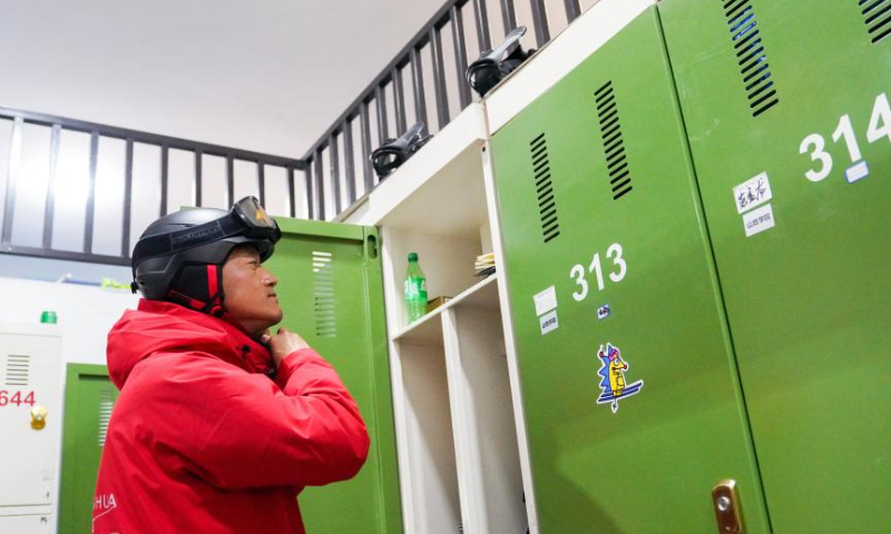 Ski coach Zhang Zhanhua puts on his snow gear at the Lake Songhua Resort in Jilin City, northeast China's Jilin Province, Nov. 20, 2022. Jilin Province is taking advantage of its ice-snow resources in winter as it seeks new growth drivers for rural development. (Xinhua/Yan Linyun)