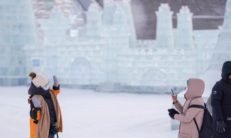 A visitor poses for pictures at the Harbin Ice-Snow World, a renowned seasonal theme park, in Harbin, northeast China's Heilongjiang Province, Dec. 17, 2022. The theme park underwent a test run on Saturday in Harbin. (Xinhua/Wang Song)