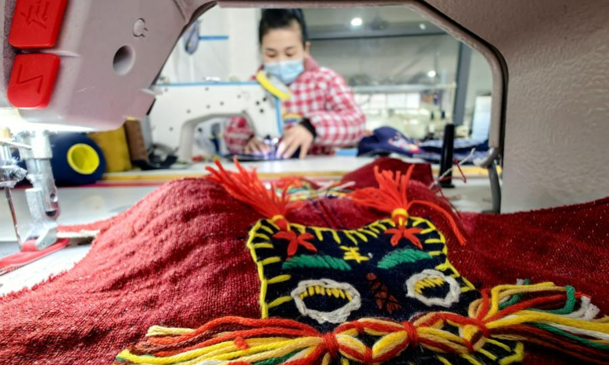 A woman makes traditional Chinese cloth shoes at a factory in Heze, east China's Shandong Province, Dec 1, 2022. Photo:China News Service