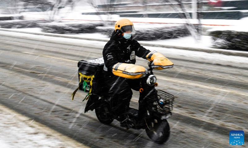 A food delivery courier rides along a road during a snowfall in Changchun, northeast China's Jilin Province, Nov. 12, 2022. A snowfall hit some parts of Jilin Province on Saturday. (Xinhua/Xu Chang)