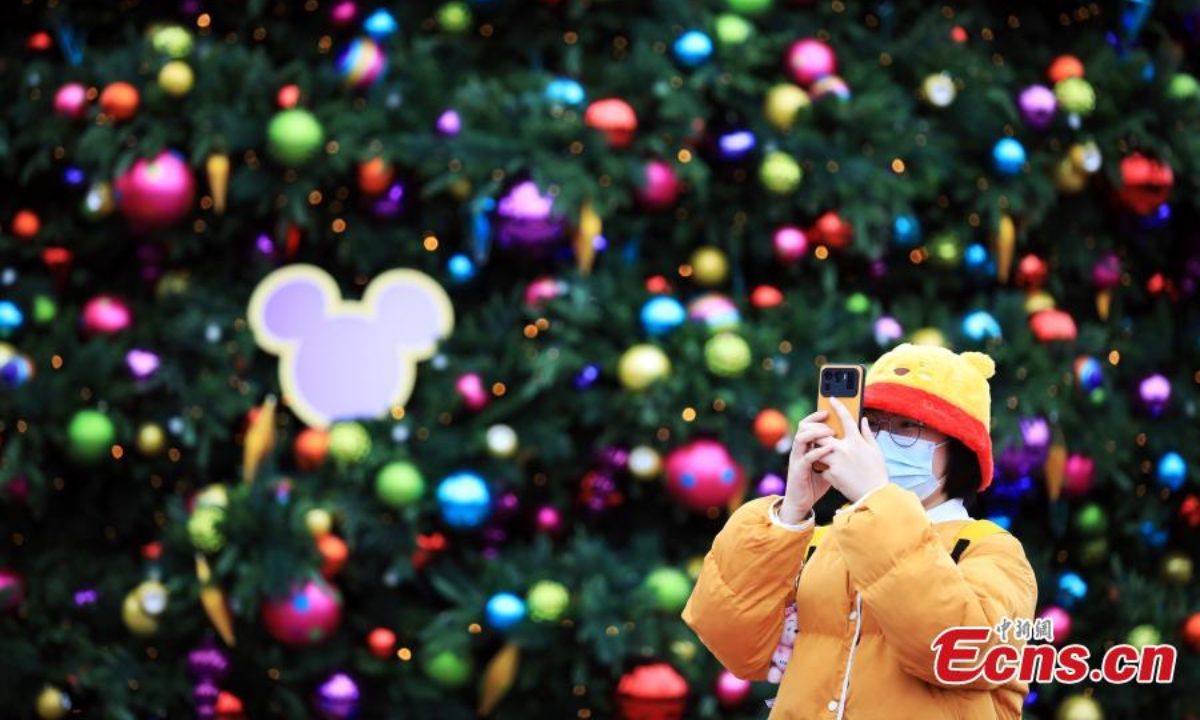 A tourist takes photos in the Shanghai Disneyland, Dec 8, 2022. Photo:Xinhua