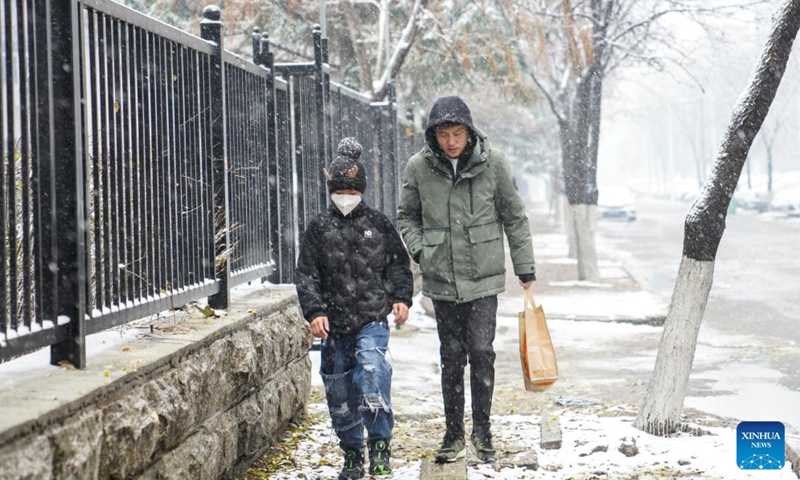 People walk during a snowfall in Jilin City, northeast China's Jilin Province, Nov. 12, 2022. A snowfall hit some parts of Jilin Province on Saturday. (Xinhua/Yan Linyun)