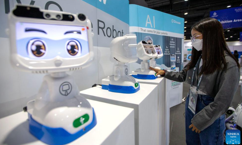 A staff member interacts with a robot at the media center of APEC 2022 in Bangkok, Thailand, Nov. 14, 2022. The 29th Asia-Pacific Economic Cooperation (APEC) Economic Leaders' Meeting will be held in Bangkok, Thailand, on Nov. 18-19. Photo: Xinhua