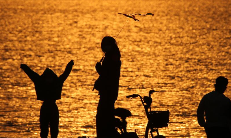 This photo take on April 15, 2022 shows people enjoying themselves along the Songhua River in Harbin, northeast China's Heilongjiang Province. Photo: Xinhua