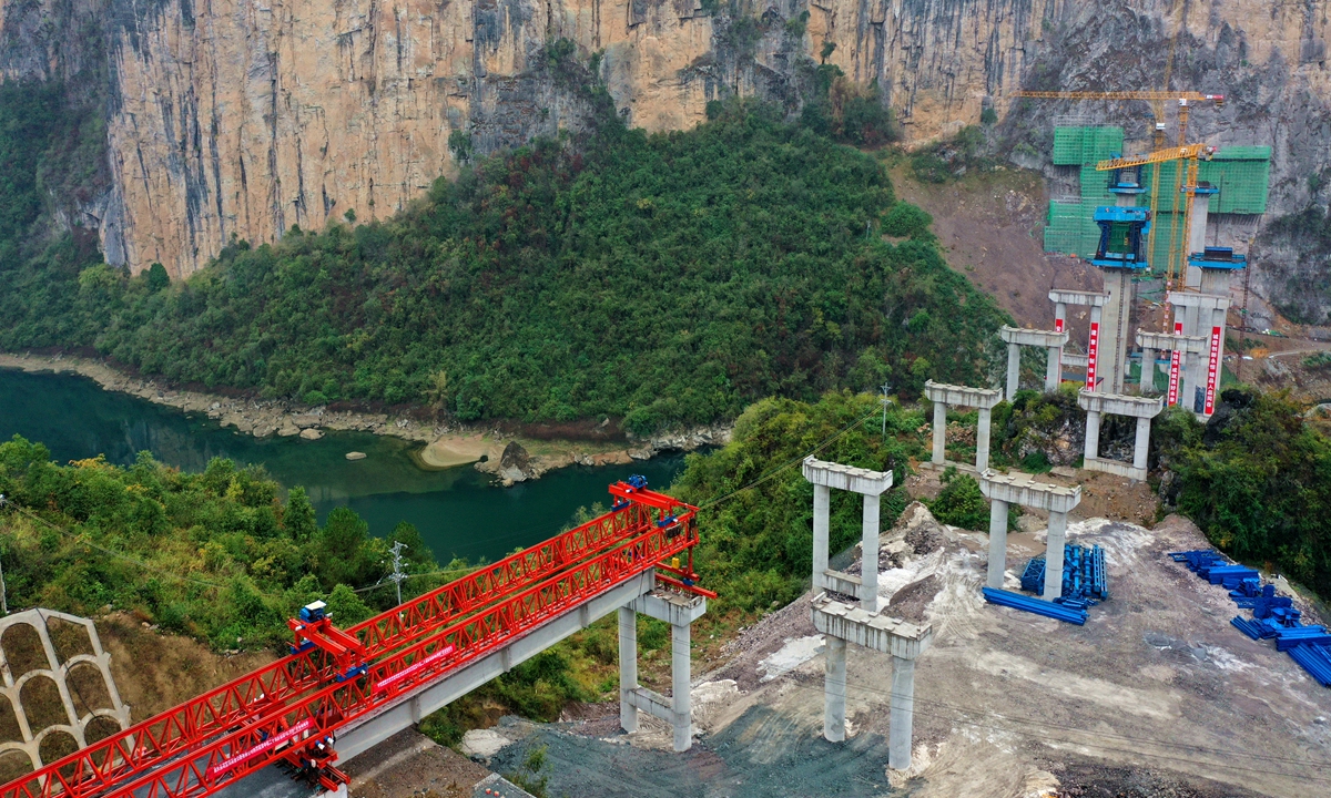 Workers set up a T-beam for the Apengjiang bridge in Youyang county, Southwest China's Chongqing Municipality on November 13, 2022. The 514-meter long bridge is a key project along the double-track expressway linking Chongqing and Central China's Hunan Province. Photo: VCG