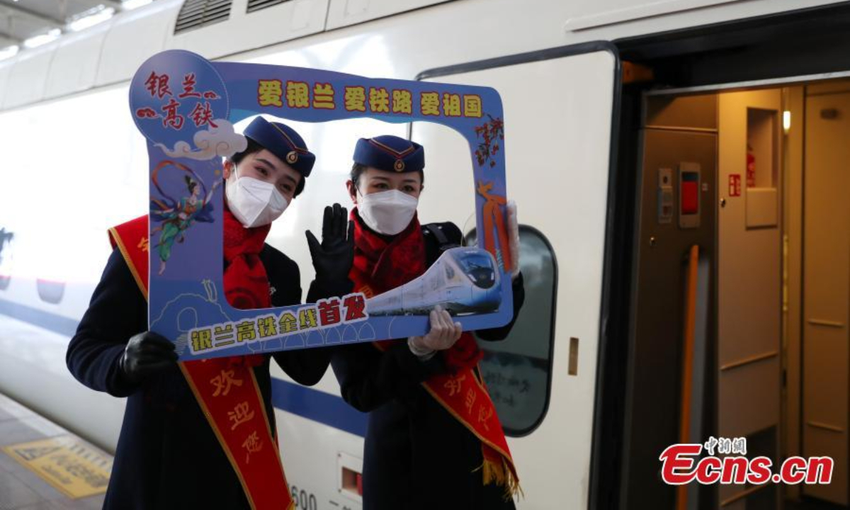 Staff members pose for a photo in front of the first train at the Yinchuan Railway Station in northwest China's Ningxia Hui Autonomous Region,Dec. 29, 2022. Photo: China News Service