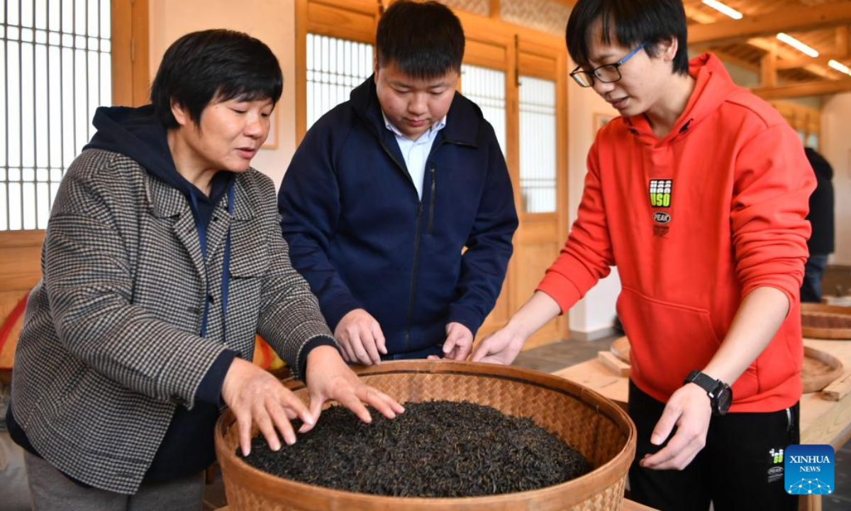 You Yuqiong (L), the only female inheritor of Wuyi rock tea making technique, instructs her son Fang Zhou (C) in the roasting technique of Wuyi rock tea in Wuyishan, southeast China's Fujian Province, Dec 1, 2022. Photo:Xinhua