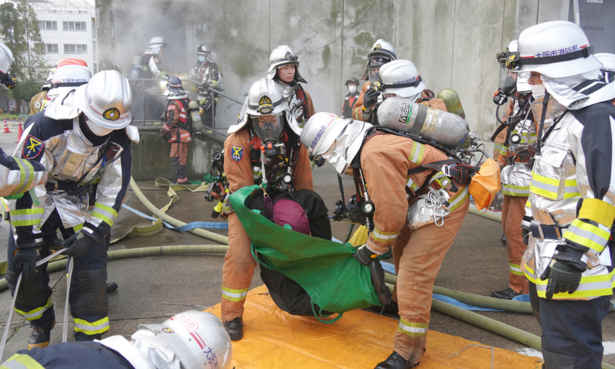 Firefighters attend a fire drill conducted under the assumption that a fire has broken out in a “specified one-staircase fire protection object” in Osaka, Japan on December 22, 2022. Photo: AFP